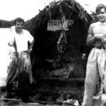 Che Guevara et Alberto Granado debout devant leur radeau Mambo sur un fleuve sud-américain lors de leur voyage exploratoire.